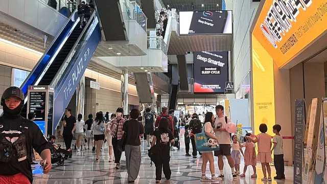 코엑스 로비 관람객 인파와 박람회 안내 전광판